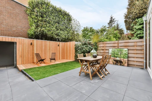 Upgraded Main Line backyard patio with wood fencing and outdoor dining set
